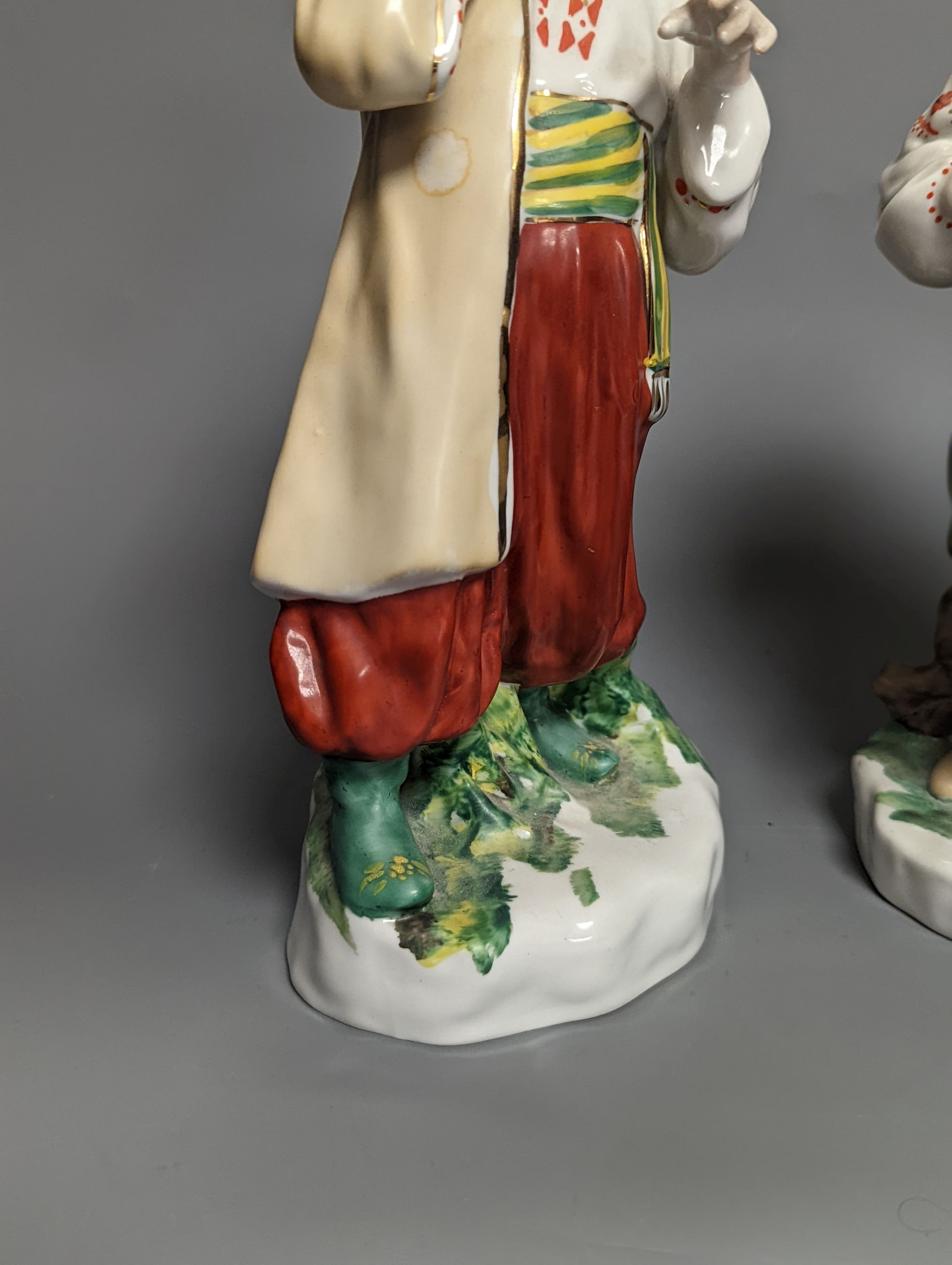 A pair of Russian porcelain figures of a Cossack and his wife 25cm